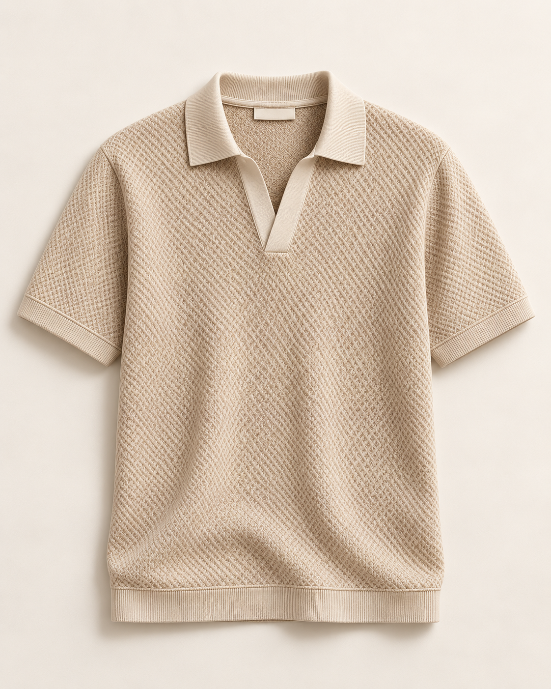 Pisani (S03), polo beige a collo aperto e trama a nido d’ape; capo intero con maniche e fondo visibili.