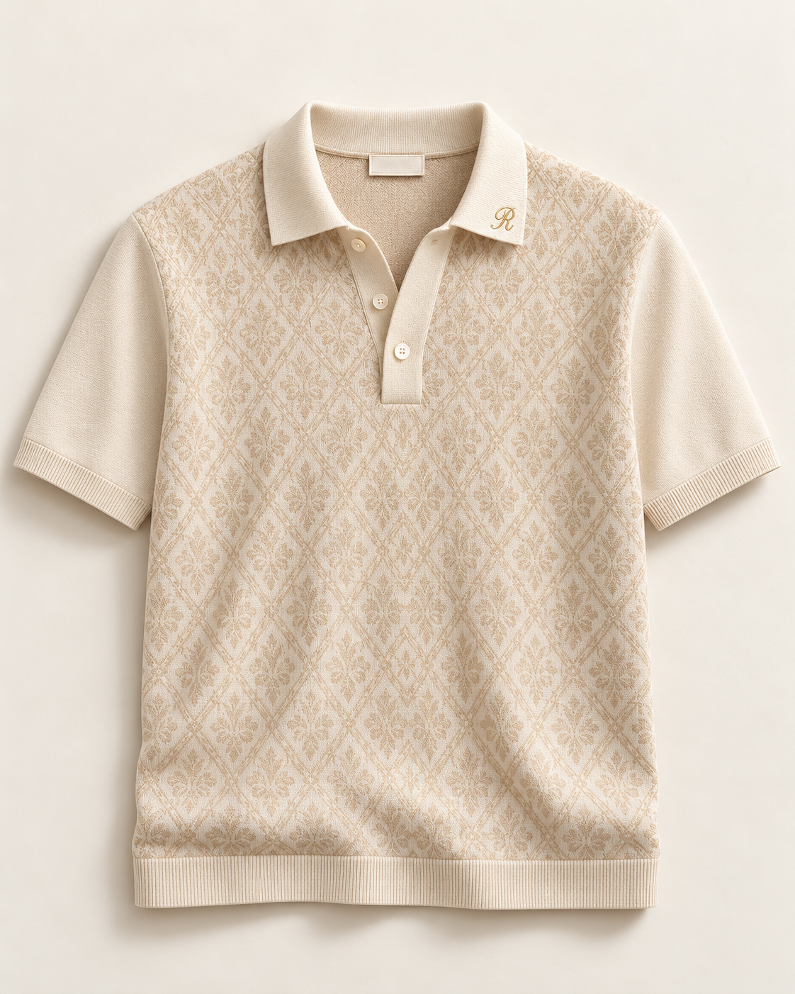 Querini (S05), polo avorio jacquard con apertura a bottoni e ricamo R; capo intero con maniche e fondo visibili.